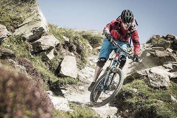 Mountain biker riding through dry, rocky terrain